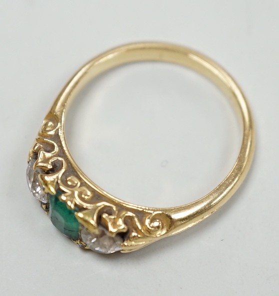 An early 20th century yellow metal, emerald and diamond set three stone ring, size L, gross weight 4.2 grams.
